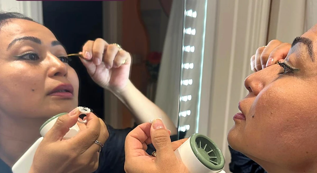 A close-up lash beauty moment at an illuminated mirror